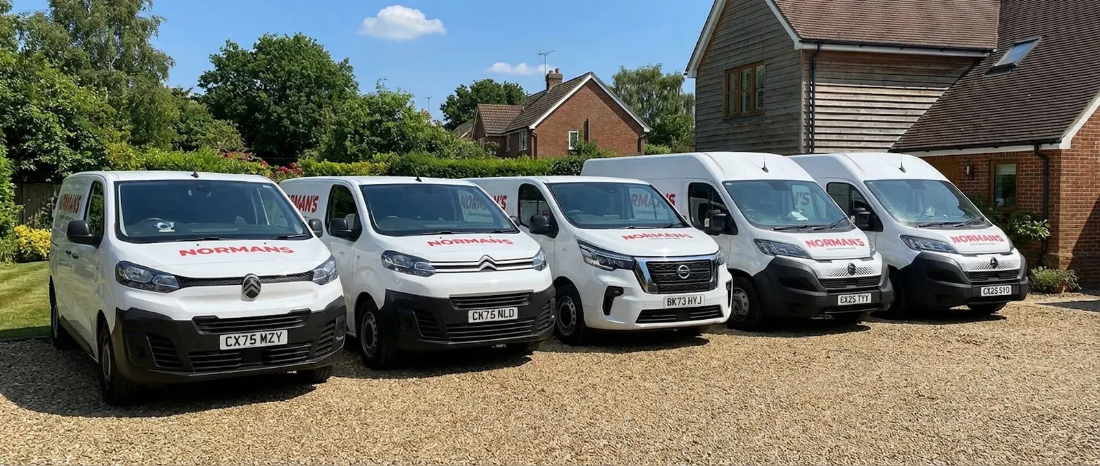 The Normans Cleaning fleet of branded vans parked on a driveway