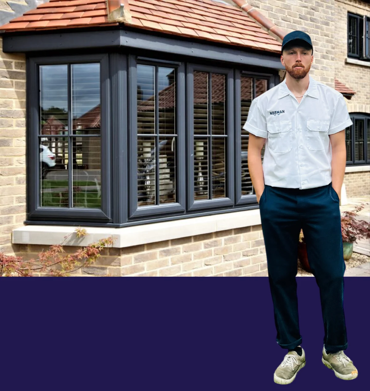 A Normans Cleaning team member in front of a freshly cleaned bay window